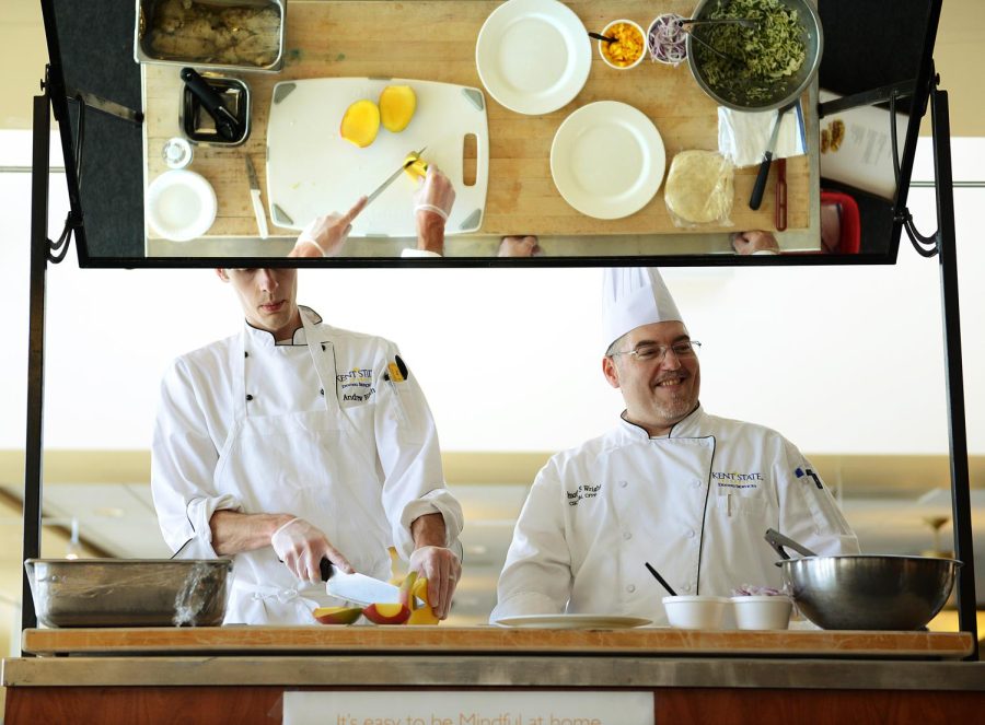 Chefs Andrew Eith and Timothy Wright prepare grilled fish tacos with mango slaw for a food demonstration introducing Kent State's new "mindful" menu items. Photo courtesy of Kent State Dining Services.