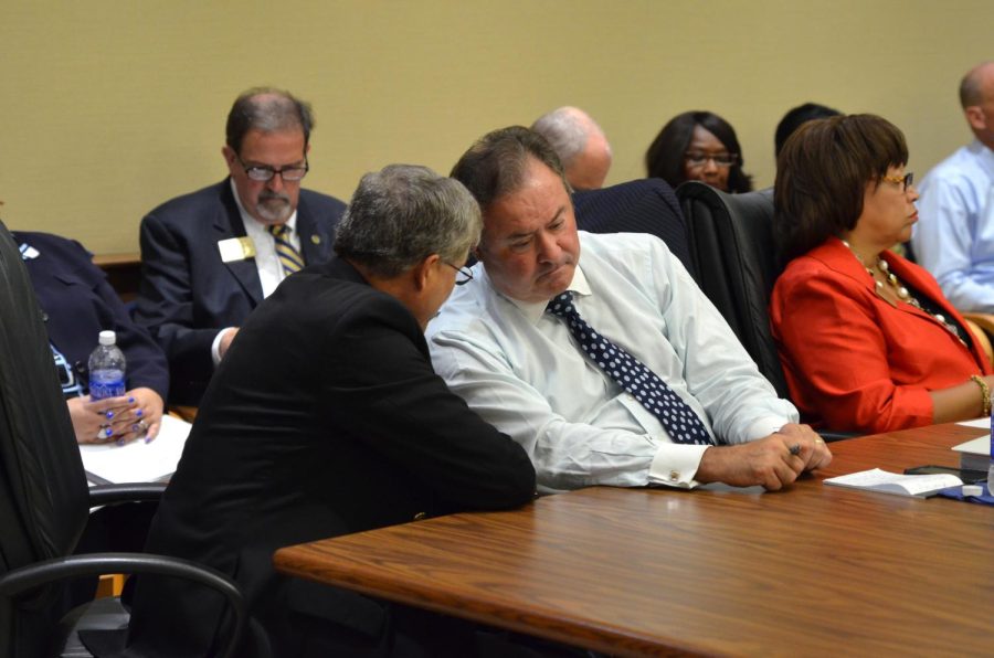 Chair Dennis Eckard shares a word with Ralph Ratta during the Board of Trustees meeting on Wednesday, Sept. 9, 2015.