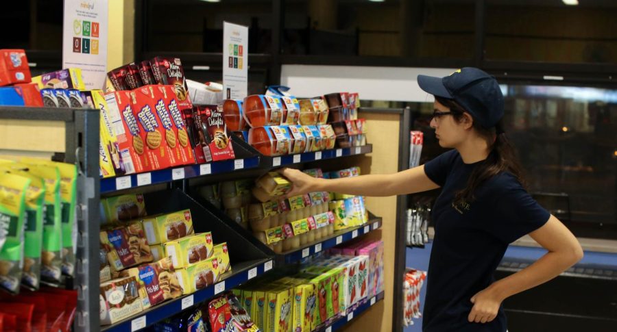 Junior english major, Korrine Engber, stocks the shelves of Munchie’s Market on Sunday, Oct. 11, 2015.