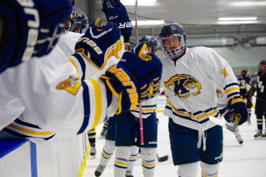 Forward Jake Haneline skates past the bench for celebratory high fives after the team scored on Western Michigan University Friday, Oct. 9, 2015.