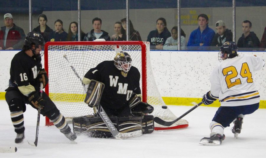 Senior forward Miles Radosevic takes a shot at the goal during a game at the Kent State Ice Arena on Oct. 9, 2015. The Flashes lost the game in a shootout 7-4.