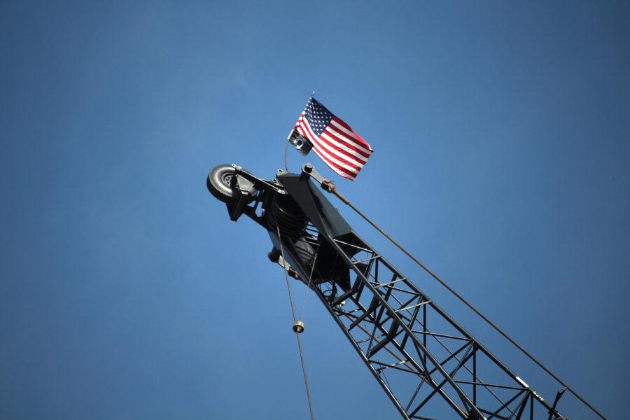 An American and a POW MIA flag sits on top of a crane inside the new College of Architecture &amp; Environmental Design construction zone Wednesday, Oct. 21, 2015.