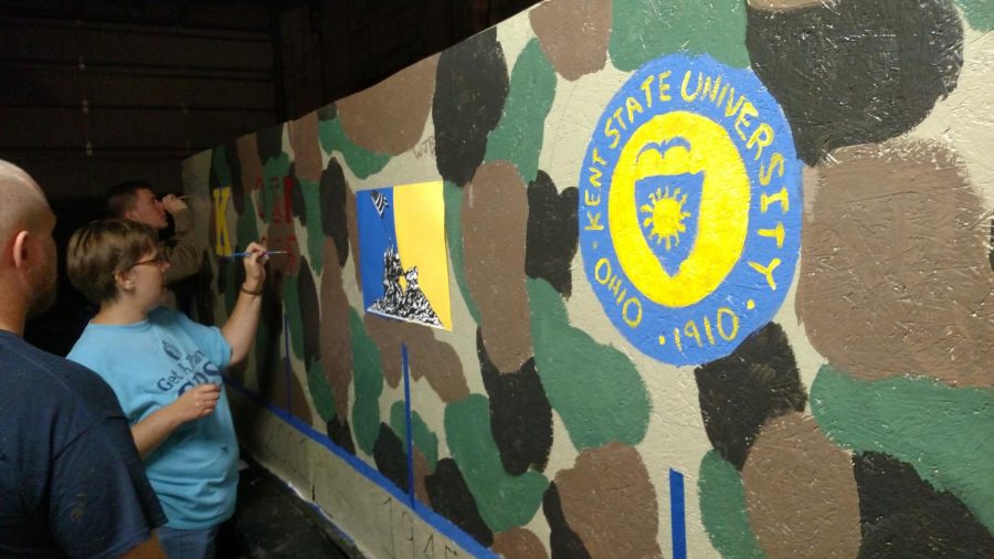 Tiffany Hawley, Will Bustos, and Brandon Crites paint a Homecoming parade float they built for the Homecoming parade to honor the U.S. Marines on Wednesday, Sept. 30, 2015.