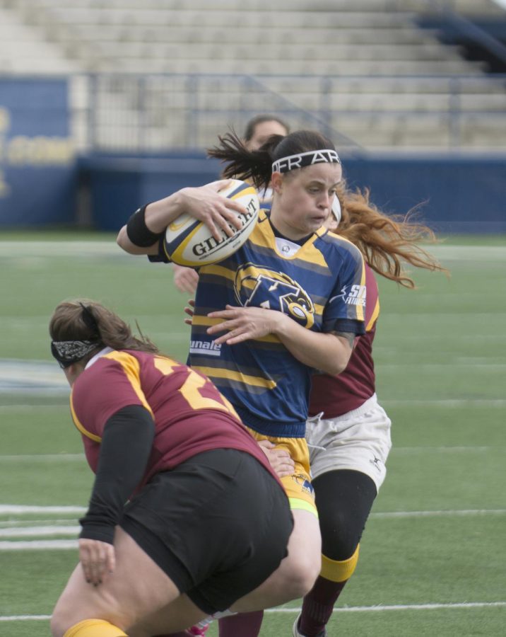 Sophomore Holly Chesnick tries breaking free with the ball during the Kent State women's rugby game against Central Michigan at Dix Stadium on Saturday, Oct. 17, 2015. Kent state won big against Central Michigan with a final score of 81-10.