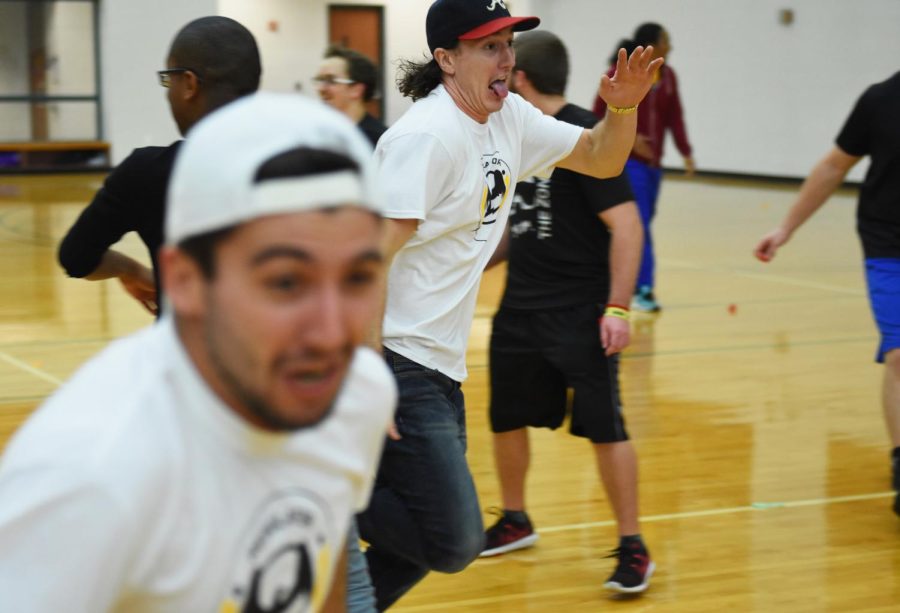 Sophomore Caleb Gannelli and other embers of the Kent State Hockey team run across the gym floor as participants in The Reaping attempt to stick colored tape to them on November 6, 2015.