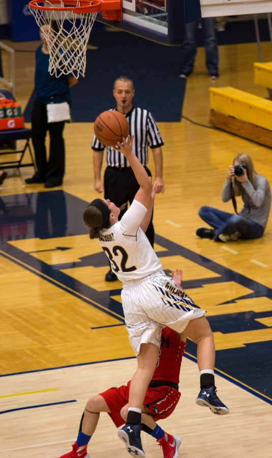 Freshman guard, Paige Salisbury, goes up for a layup knocking down a Hiram defender on Sunday Nov. 8, 2015. Salisbury made the layup and drew a blocking call for an “and one,” she missed.