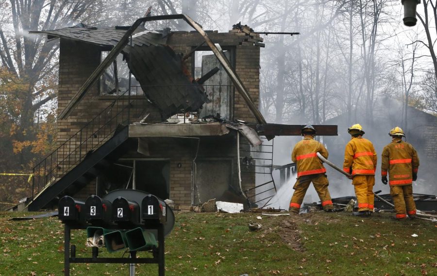 Area police and firefighters work at the scene after a passenger jet crashed into a home on Mogadore Rd. while on a short approach to Akron-Fulton Airport on Tuesday, Nov. 10, 2015, in Akron, Ohio. An undetermined amount of people died in the accident.