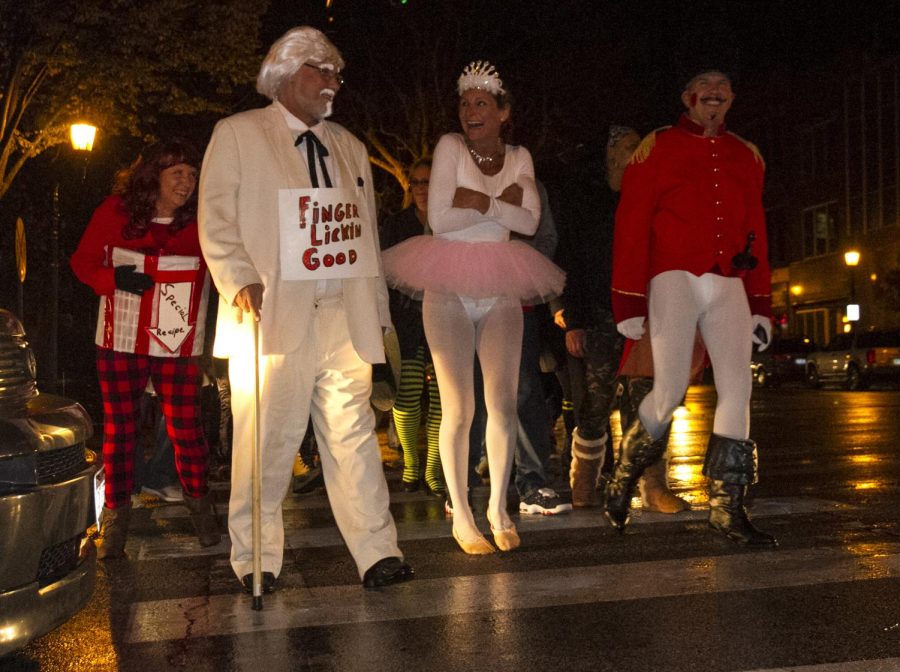 Costumed partygoers cross traffic in downtown Kent on their way to the Zephyr Pub for the Halloween festivities on Oct. 31, 2015.