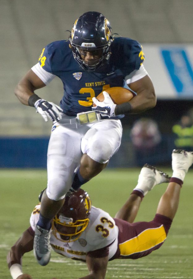 Senior running back Trayion Durham leaps over a CMU defender during a game versus Central Michigan University on Wednesday, Nov. 18, 2015.