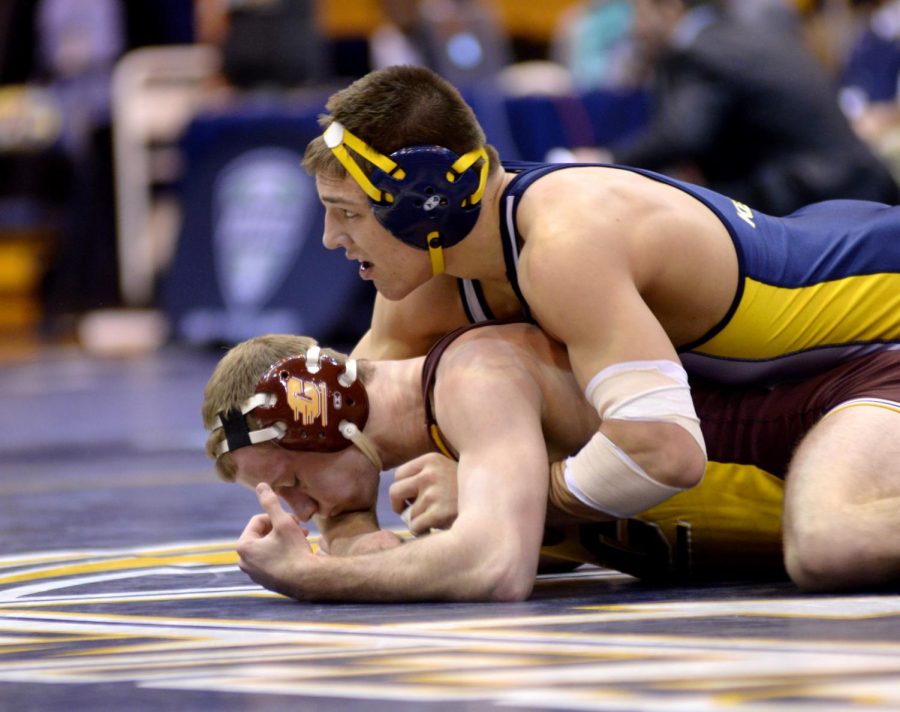 Kent State's Ian Miller pins his opponent and watches as the time ends in his final match of the MAC Championship Sunday, March 9, 2014. Miller defeated his opponent from Central Michigan and finished first in his weight class winning him a Mid-American Conference title.