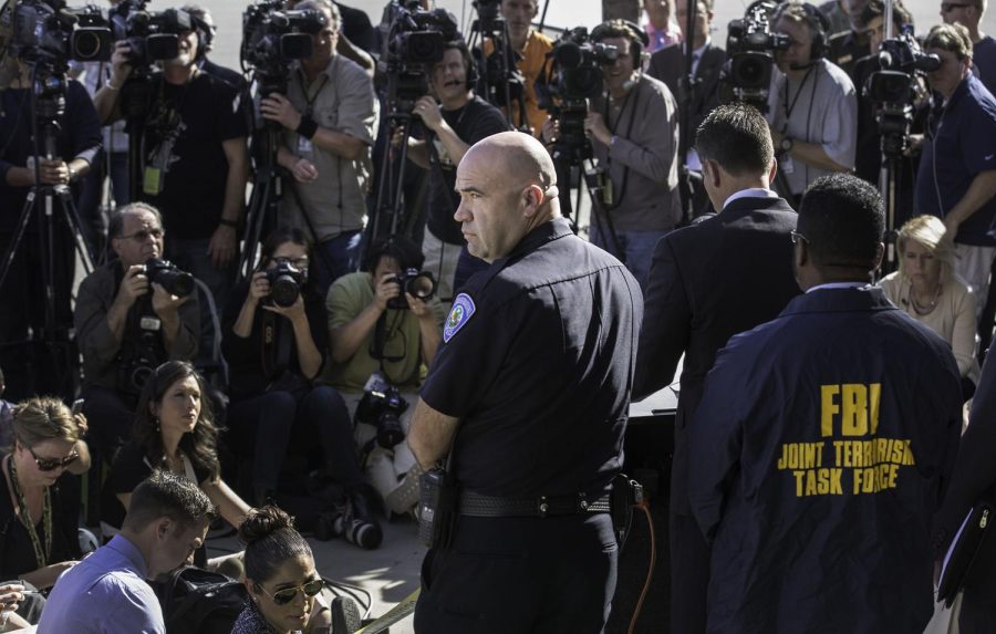 San Bernardino Police Chief Jarrod Burguan, center, is surrounded by reporters and photographers during a news conference at San Bernardino Police headquarters in San Bernardino, Calif., on Dec. 7, 2015. 