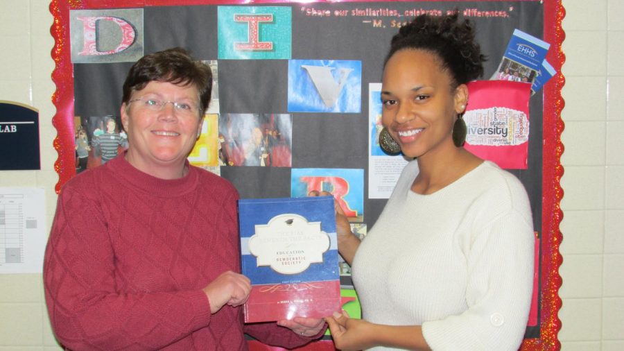 Debra Clark and Cristin Williams, a middle childhood education major, hold Clark's textbook "The Bias Beneath the Facts: Education in a Democratic Society." Williams received the Clark International Travel Scholarship.