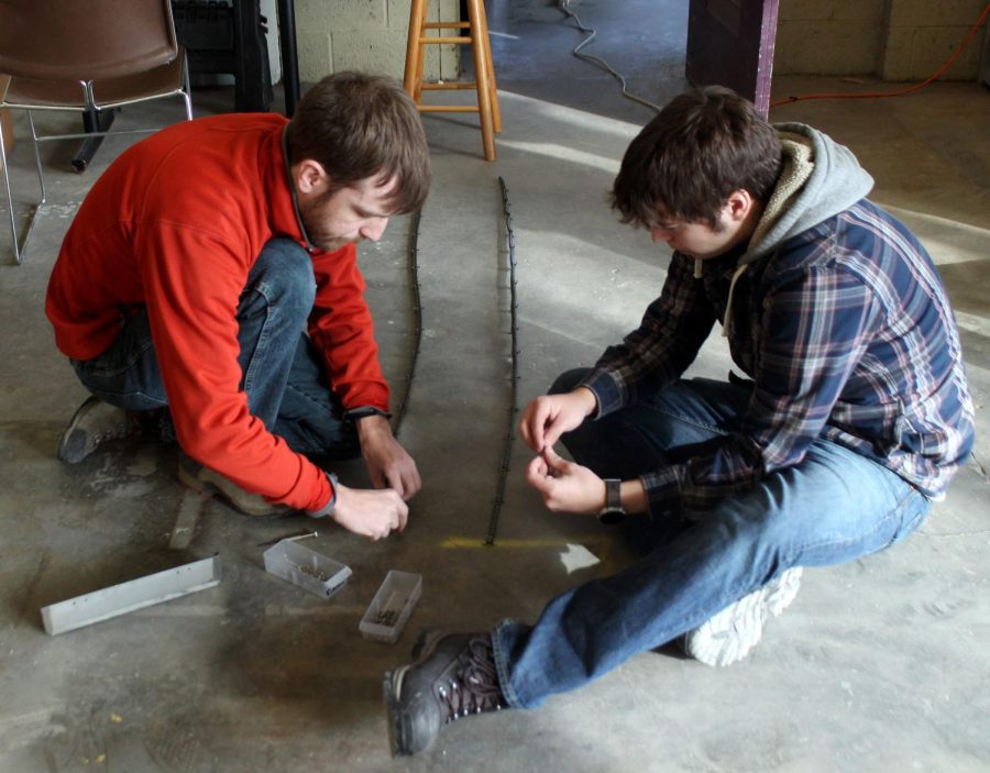 Rick Szalay (left) and Sage Edwards (right) assemble the track for their robot before the practice robotics competition on Saturday, Feb. 6, 2016. Teams from Virginia Tech, Akron University and Iowa State gathered in the Schwart’s Center at Kent State to practice for their robotics competition in May.