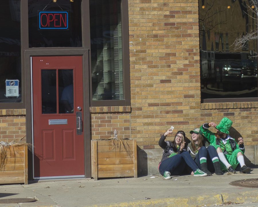 Evan Paul, dressed in a full green suit, gets in a selfie with two girls outside of the Venice Cafe in downtown Kent on Patrick's Day on March 17, 2015.