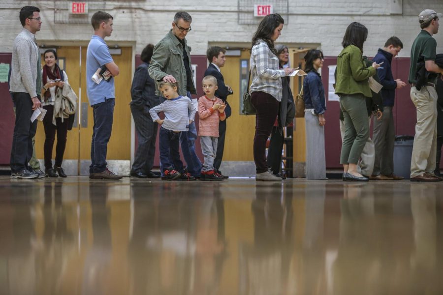 Steve Amos with sons, Cy, 5, left, and Leon, 5, join voters in line to vote at Henry W. Grady High School on March 1, 2016 in Atlanta, Ga.