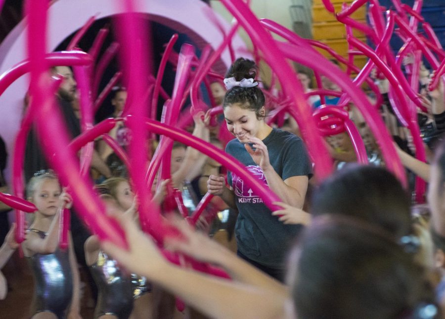 Kent State University freshman Michaela Romito runs through a tunnel of pink balloons held by young gymnastic teams from around Portage county during the Flip for the Cure gymnastics meet in the M.A.C. Center on Sunday, Mar. 1, 2015. The Flip for the Cure event included a Pinkest fan competition, breast cancer survivor recognition, and various other promotions and activities all to raise money for the COSA Comprehensive Breast Center - COSA CARES program.