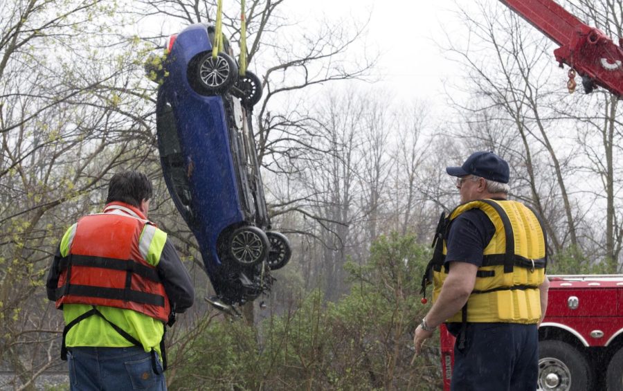 Emergency crews lift a car out the Cuyahoga River off North Mantua St. on Friday, April 22, 2016.