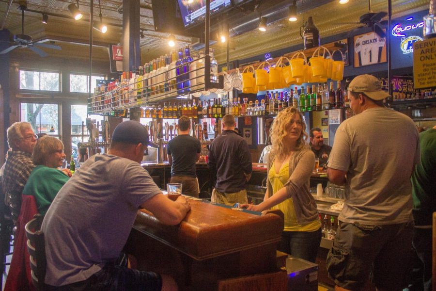 Customers sit at the bar of Water Street Tavern on Friday, April 15, 2016.