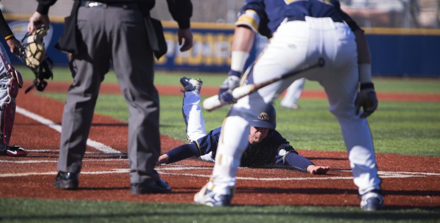 Junior Sam Hurt slides into home following redshirt junior Luke Burch in the third inning of the game against The Ohio State University on Tuesday, April 5, 2016.