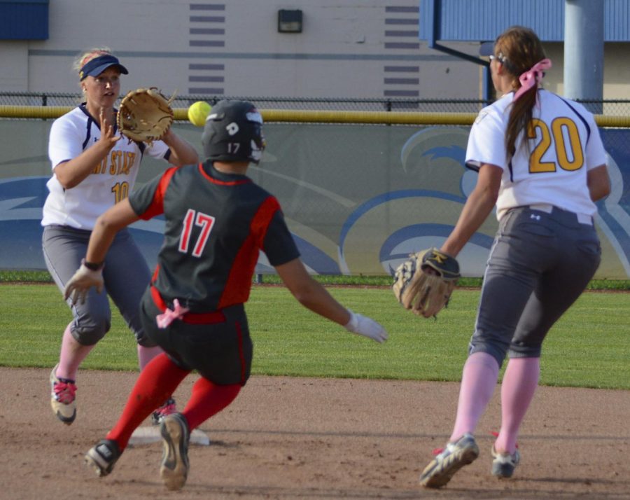 Then a sophomore, infielder Holly Spears catches a ball tossed by former Kent State infielder Michele Duffy in a rundown with a Youngstown State player on April 25, 2017. [FILE]