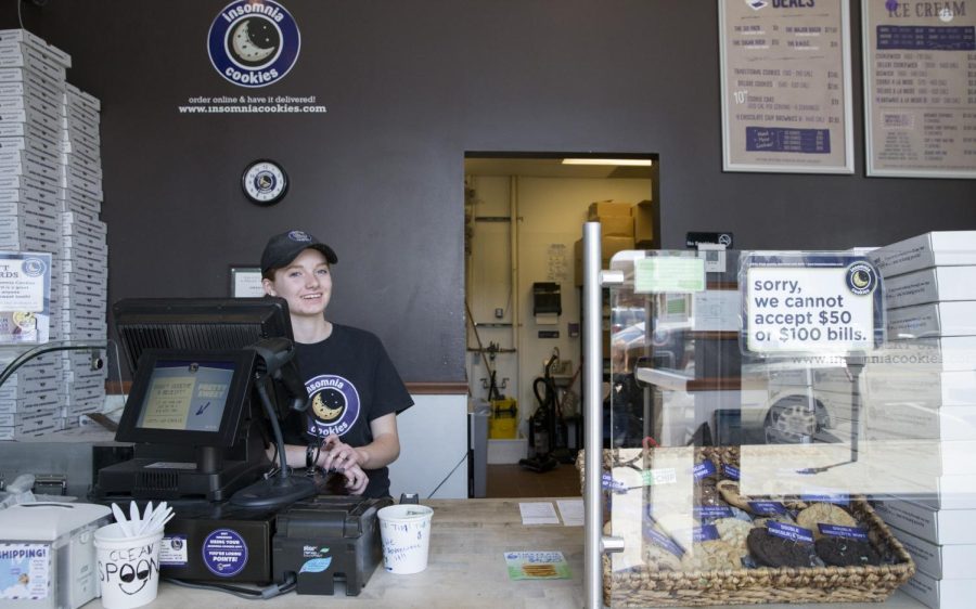 Freshman journalism major Serina Barry, an employee of Insomnia Cookies, poses behind the counter of the storefront on Wednesday, April 20, 2016.