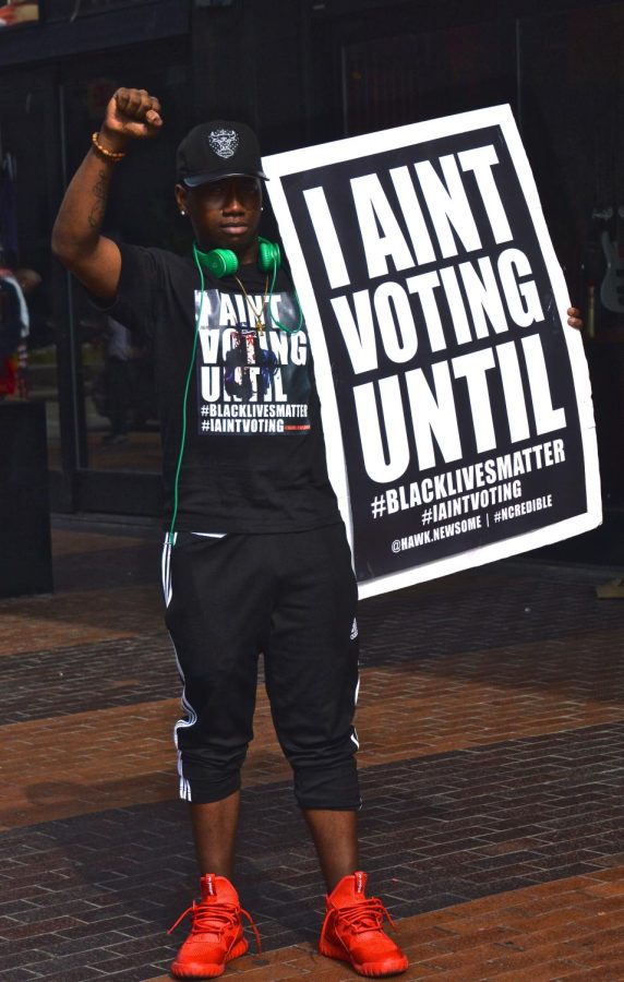 Black Lives Matter protestor Christian Lewis poses on the sidewalk of Euclid Avenue in downtown Cleveland on Monday, July 18, 2016. 