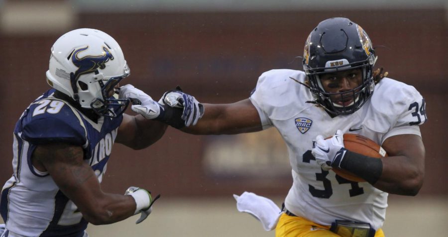 Kent State senior running back Trayion Durham stiff arms Akron senior cornerback Bryce Cheek at Infocision Stadium on Friday, Nov. 27, 2015. Durham’s run was called back due to a holding call. Akron shut out the Flashes 20-0.