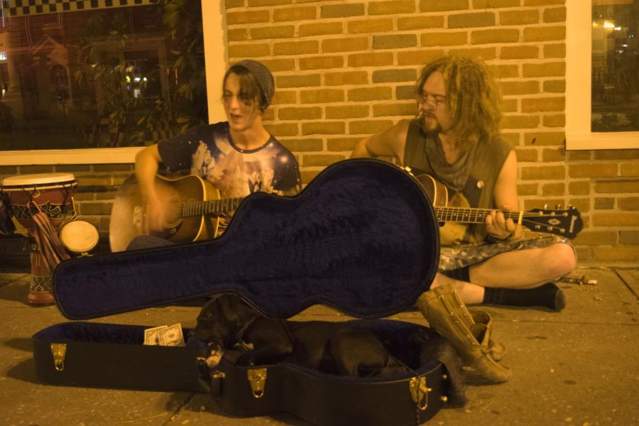 From Left: Logan Lott and Matta Taylor playing their guitars while their dog Lucy rests in a guitar case in Downtown Kent on Thursday, Sep. 22, 2016.