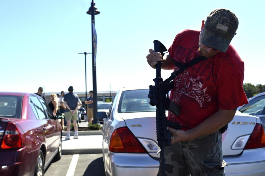 Alexander Wadley / The Kent Stater Ray Oak, Truck Driver, 37, inspects his Stag AR-15 rifle in preparation for the Open Carry/Firearm Education Walk at Kent State Sept. 24, 2016. “I believe anyone should be able to carry at any time. If you’re an adult and you’re able to go to war you should be able to carry a gun on campus. Just because you walk on campus doesn’t make you a criminal and mean they can take away your rights.” said Ray Oak.