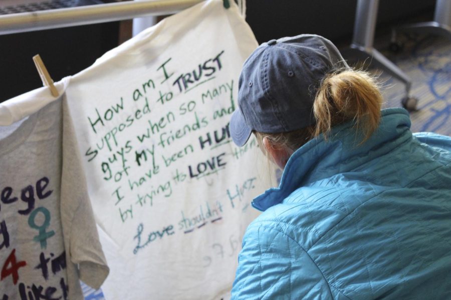 Bella Adornetto, a Kent State sophomore criminology and justice studies major, looks at shirts at the Clothesline Project display in the Student Center on Tuesday, Oct. 25, 2016.