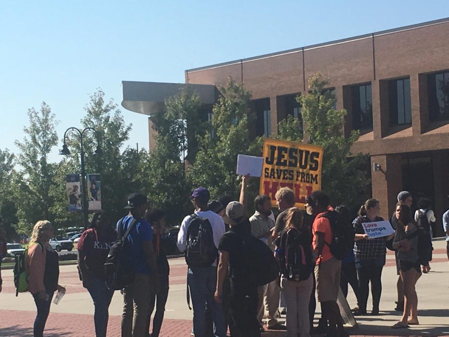 Students gather around religious protester in Risman Plaza on Oct. 6, 2016. Some students carried signs that read "Free Hugs" and "Love Trumps Hate".