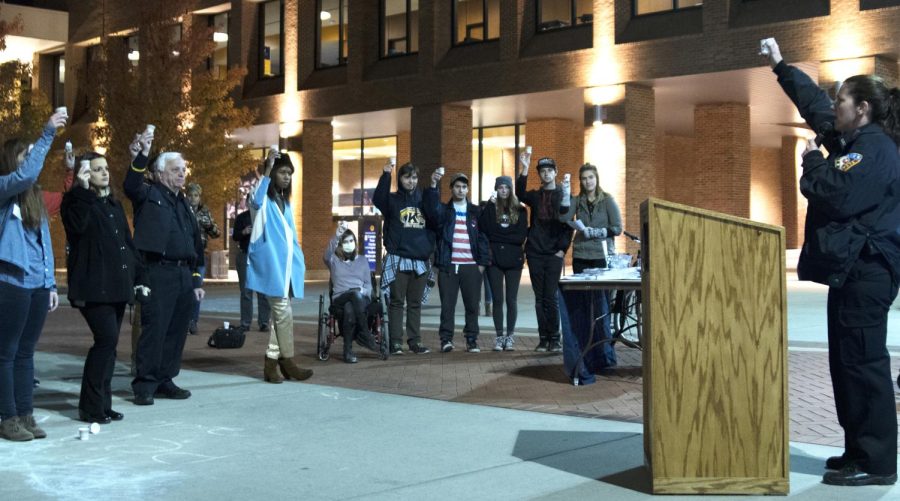 Kent State community members  gathers at the "Rise up to Heroin/Opiate Addiction" vigil on Risman Plaza on Tuesday, Oct. 25, 2016, holding up their “candles” at the end of Community Resource Officer Tricia Knoles’ speech.