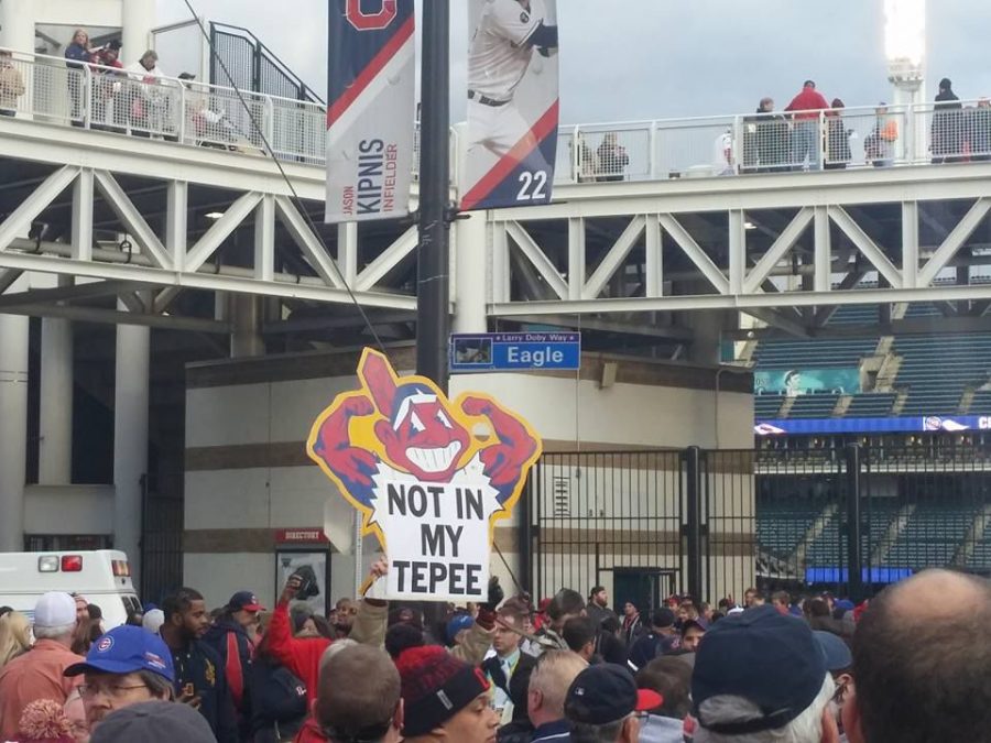 A Cleveland Indians "Not in my tepee" sign is raised above the crowd gathered outside Progressive Field in Cleveland, Ohio, during Game 1 of the World Series on Tuesday, Oct. 25, 2016. 