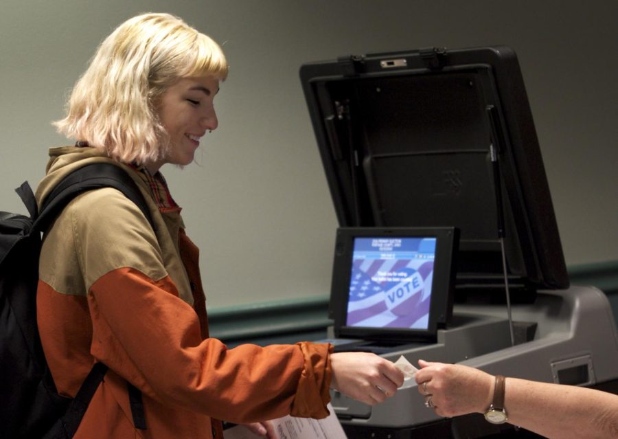 Then-freshman photo illustration major Sarah Hines receives her 'I love voting' sticker at the Kent State Student Recreation and Wellness Center on Tuesday, March 15, 2016.