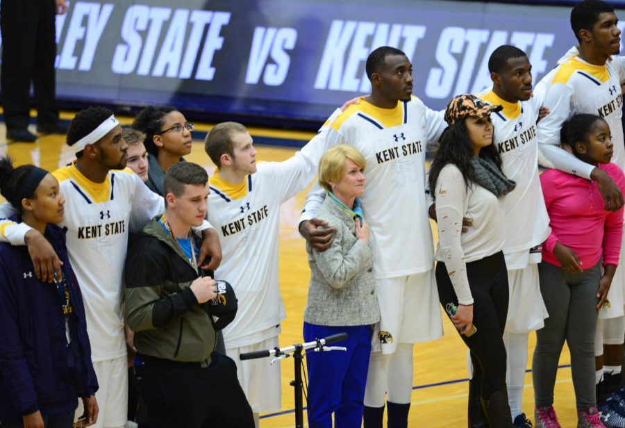 Kent State President Beverly Warren stands with the men's basketball team and members of the audience during the national anthem as a statement of unity in the face of political turmoil on Wednesday, Nov. 16, 2016.