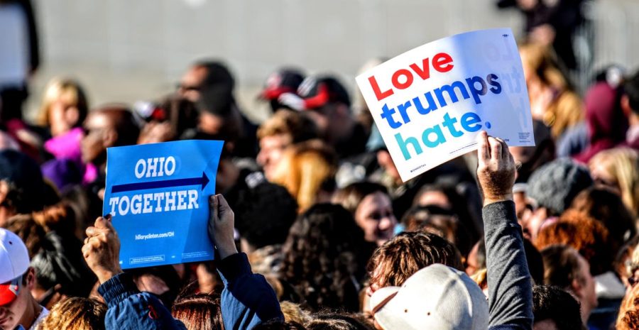 Attendees at a "Get Out The Vote" rally for Democratic presidential nominee Hillary Clinton raise campaign signs as President Barack Obama takes the podium at Burke Lakefront Airport in Cleveland, Ohio, on Friday, Oct. 14, 2016. 