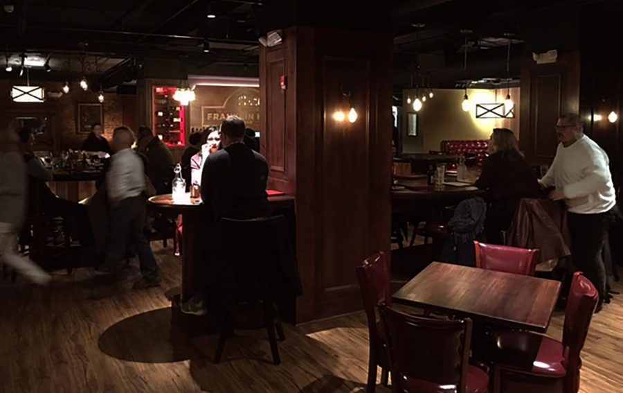 Customers eat and drink inside downtown Kent's new Franklin Hotel Bar on Tuesday, Dec. 27, 2016. Aside from booths, tables and a bar, the establishment also has a lounge area, complete with armchairs placed around an artificial fireplace. 