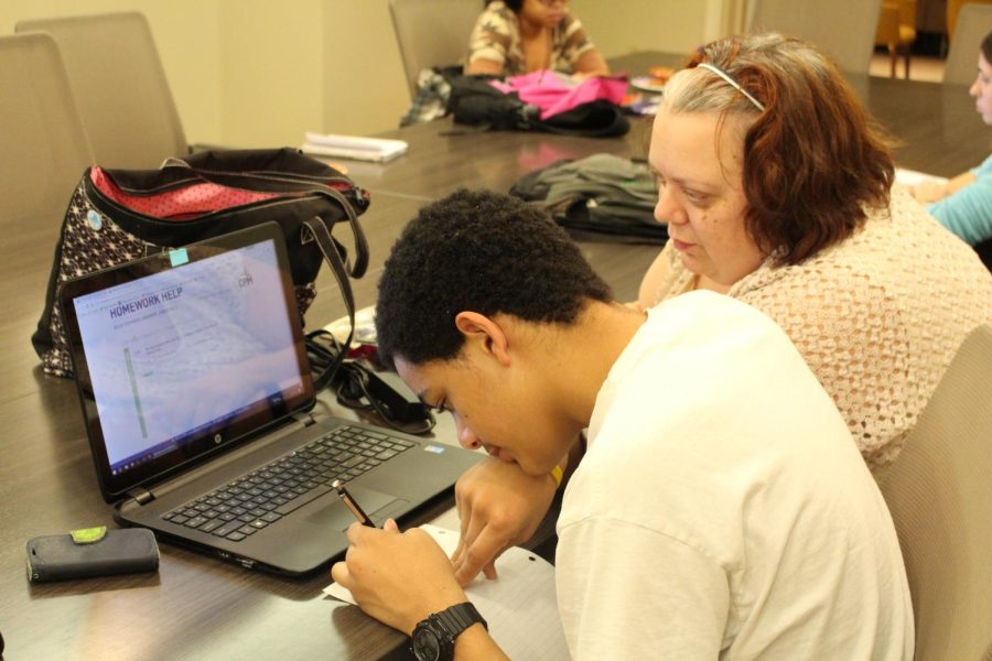 Kent State senior business management major DJ Smith assists her son with his homework during the university's Literacy and Independence for Family Education (LIFE) Program study hours on Thursday, Dec. 1, 2016. 