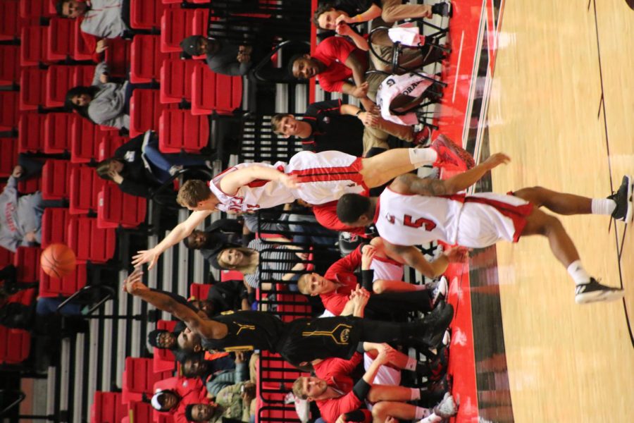 Kent State senior guard Deon Edwin takes a corner three while a Northern Illinois defender contests the shot at NIU Convocation Center on Tuesday, Jan. 24, 2017. Kent State won 73-66.