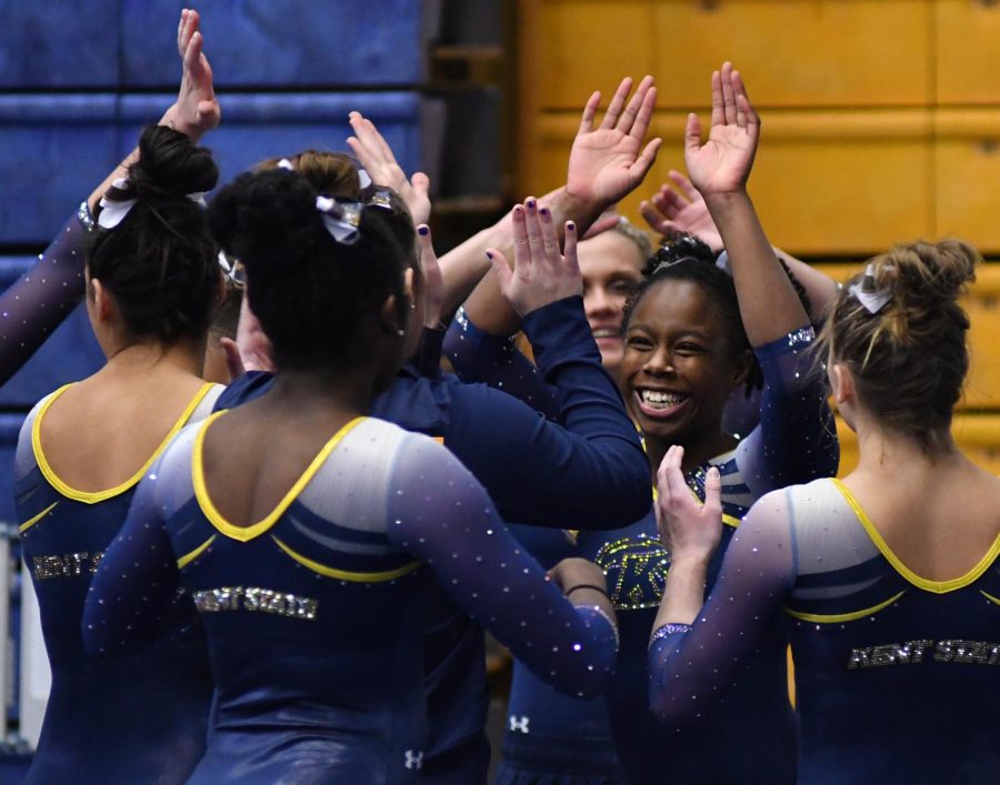 Kent State senior Jordan Hardison celebrates with her team after a successful performance on the balance beam during Kent State University's Beauty and the Beast double meet event for gymnastics and wrestling on Saturday, Feb. 4, 2017.