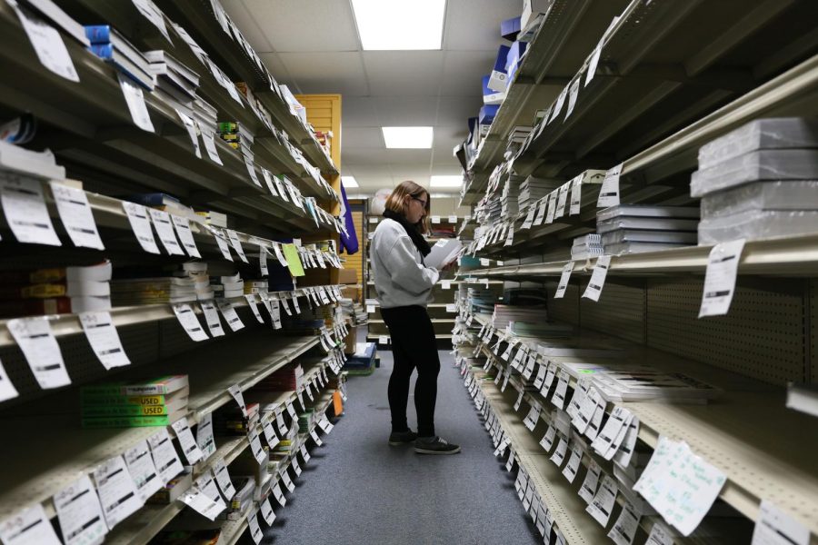 Erin Eacona, sophomore integrated health studies major, stocks shelves with textbooks at Campus Book and Supply on Tuesday, Feb. 7, 2017.