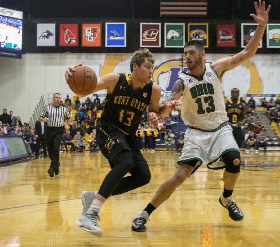 Kent State freshman guard Mitch Peterson drives the ball against Ohio University senior forward Kenny Kaminski at the M.A.C. Center on Feb. 25, 2017. Kent State won 70-67.