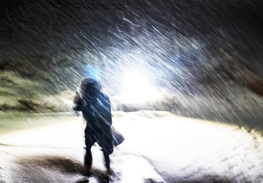 A student walks through the heavy snowfall outside Franklin Hall on the night of Tuesday, March 14, 2017.