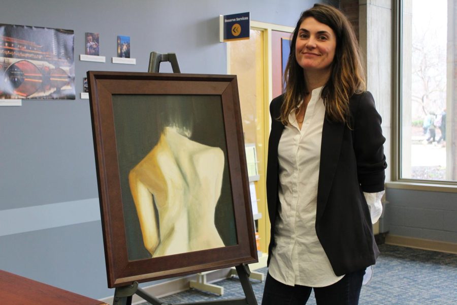 Kent State alumna, Cassie Phillips, stands next to one of her pieces that she showcased at the Women's Symposium on Wednesday, March 1, 2017.