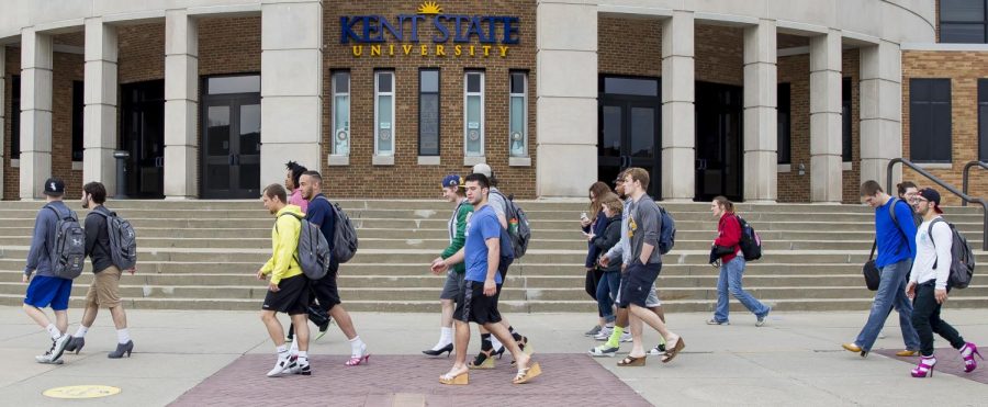 Participants of the Walk a Mile in Their Shoes event pass the M.A.C. Center Tuesday, April 11, 2017.