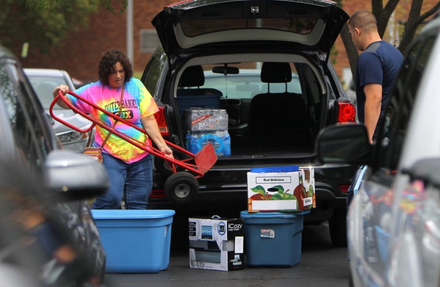 Gloria Pissos (left) takes a dolly from her car as she helps her son, new Kent State Mike Pissos move into Tri-Towers for his freshman year on Thursday, Aug. 25, 2016.