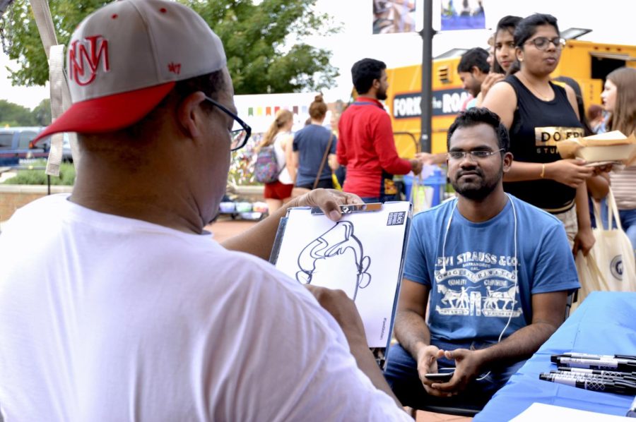 Speed sketcher Clarence Meriweather, 46, draws a caricature of digital science graduate student Bharathkumar Mudigonda at the Black Squirrel Festival Friday, Sept 9, 2016.