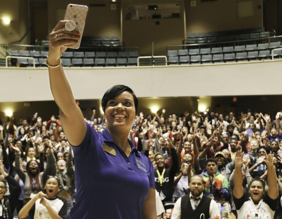 Talea Drummer, the director of the Student Multicultural Center, takes a video on her cellphone during the Kupita Transitiones closing ceremony Thursday, Aug. 24, 2017.