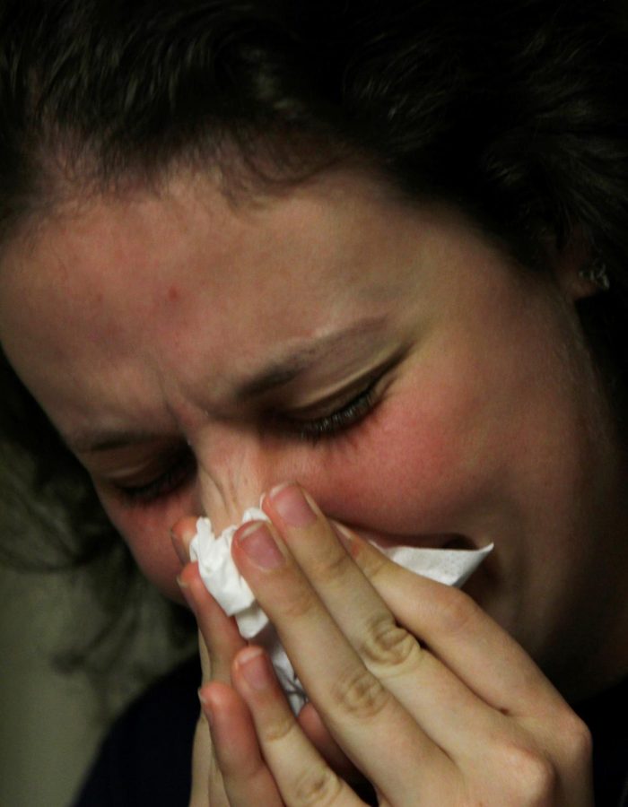 Madison MacArthur, a sophomore journalism major, blows her nose in her dorm room. She has been sick for four days.