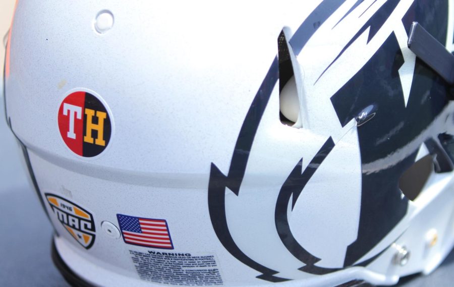 A Kent State helmet sits on the sideline adorned with a sticker for Tyler Heintz, a freshman lineman who passed away this summer during the team's conditioning. 